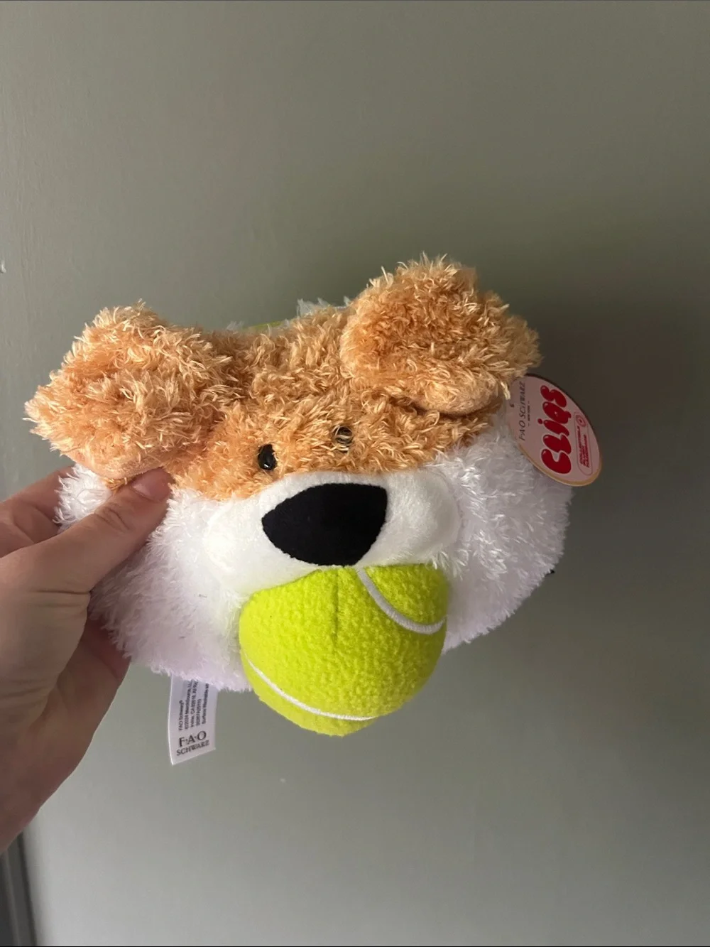 FAO Schwarz Plush Dog Face Toy with Neon Yellow Tennis Ball